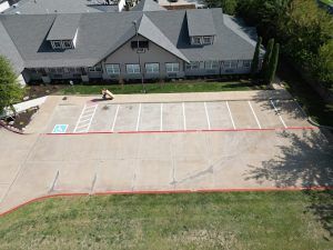 An aerial view of a parking lot in front of a building.