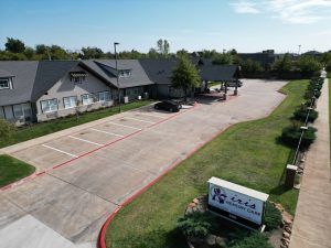 An aerial view of a hotel with a parking lot in front of it.