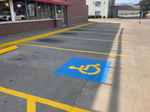 A handicapped parking spot is painted blue and yellow
