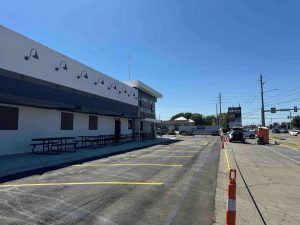 A large white building with a parking lot in front of it.