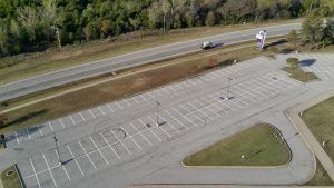 An aerial view of an empty parking lot next to a highway.
