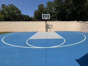 A blue and white basketball court with a basketball hoop.