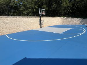 A blue and white basketball court with a basketball hoop.