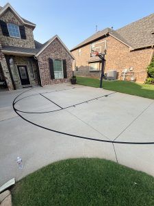 There is a basketball hoop in the driveway of a house.