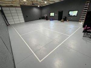There is a tennis court in the middle of the room.