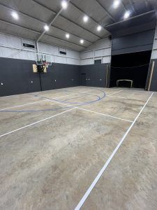 There is a basketball court in the middle of the room.