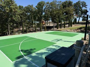 There is a basketball court in the middle of a forest.
