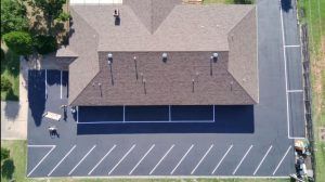 An aerial view of a house with a parking lot in front of it.