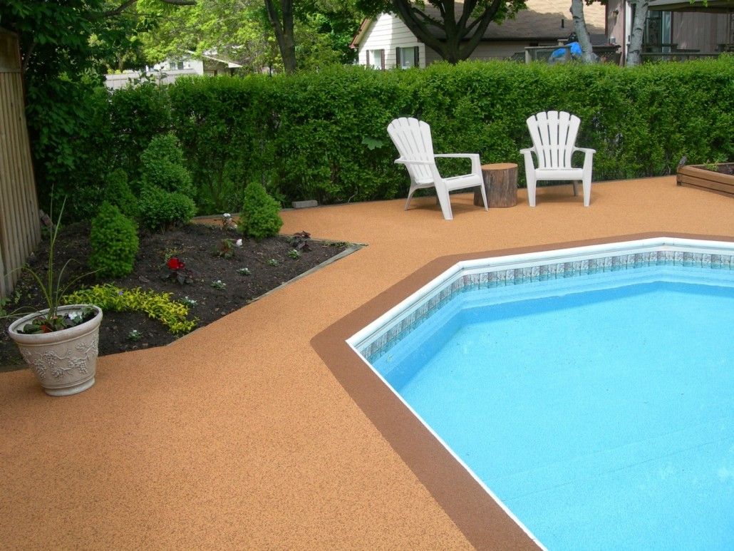 Poolside patio with white chairs, landscaping, and a rectangular pool.