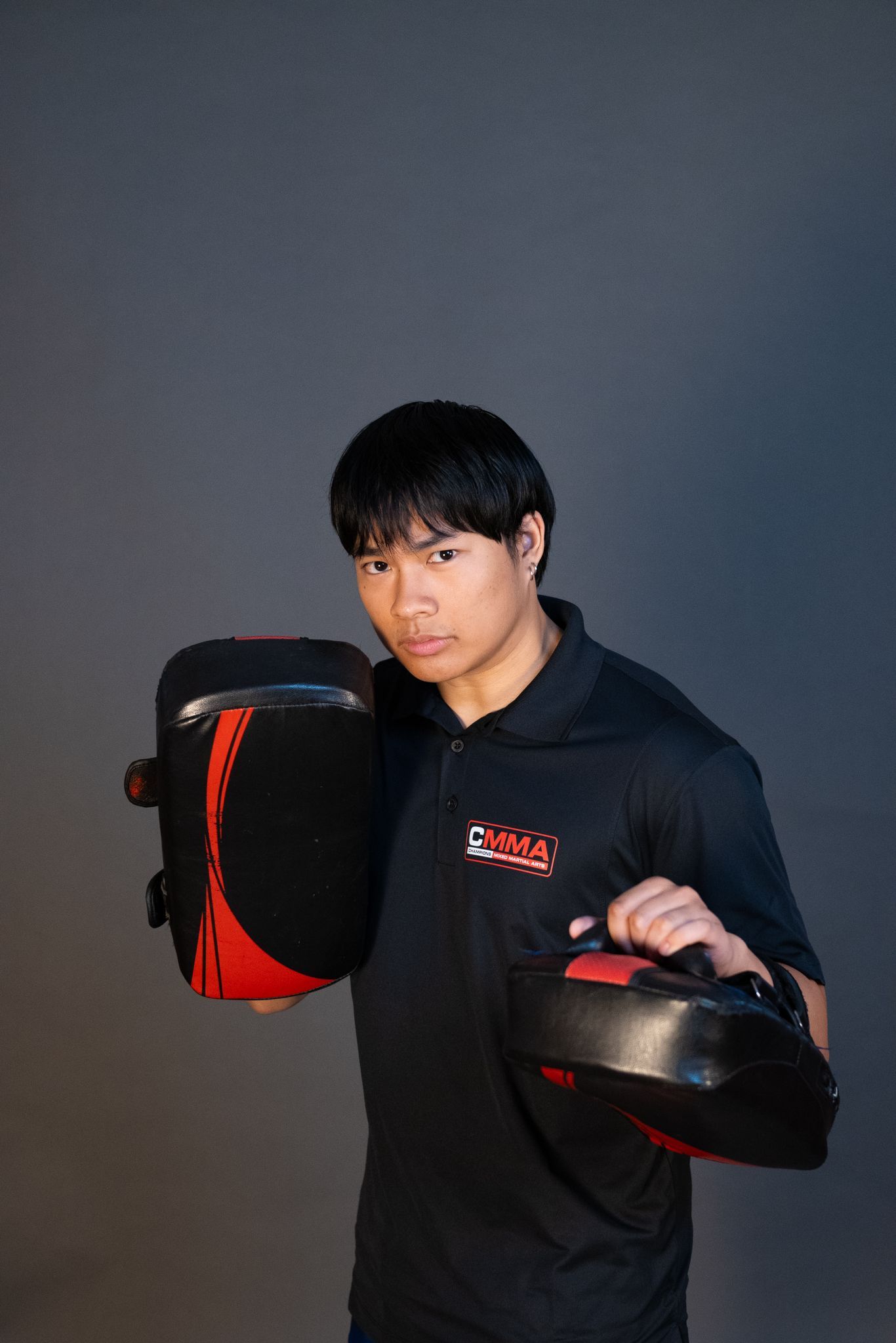 Two men in karate uniforms are posing for a picture in a gym.