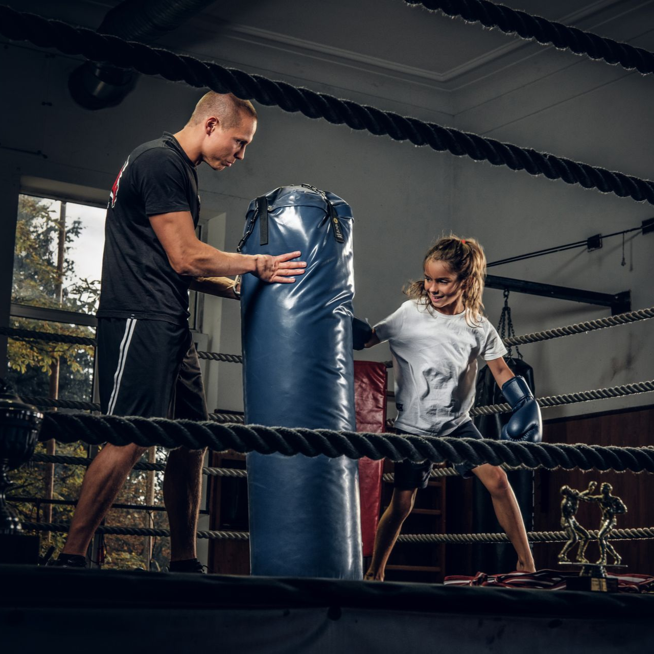 girl kicking a black back in a kickboxing studio