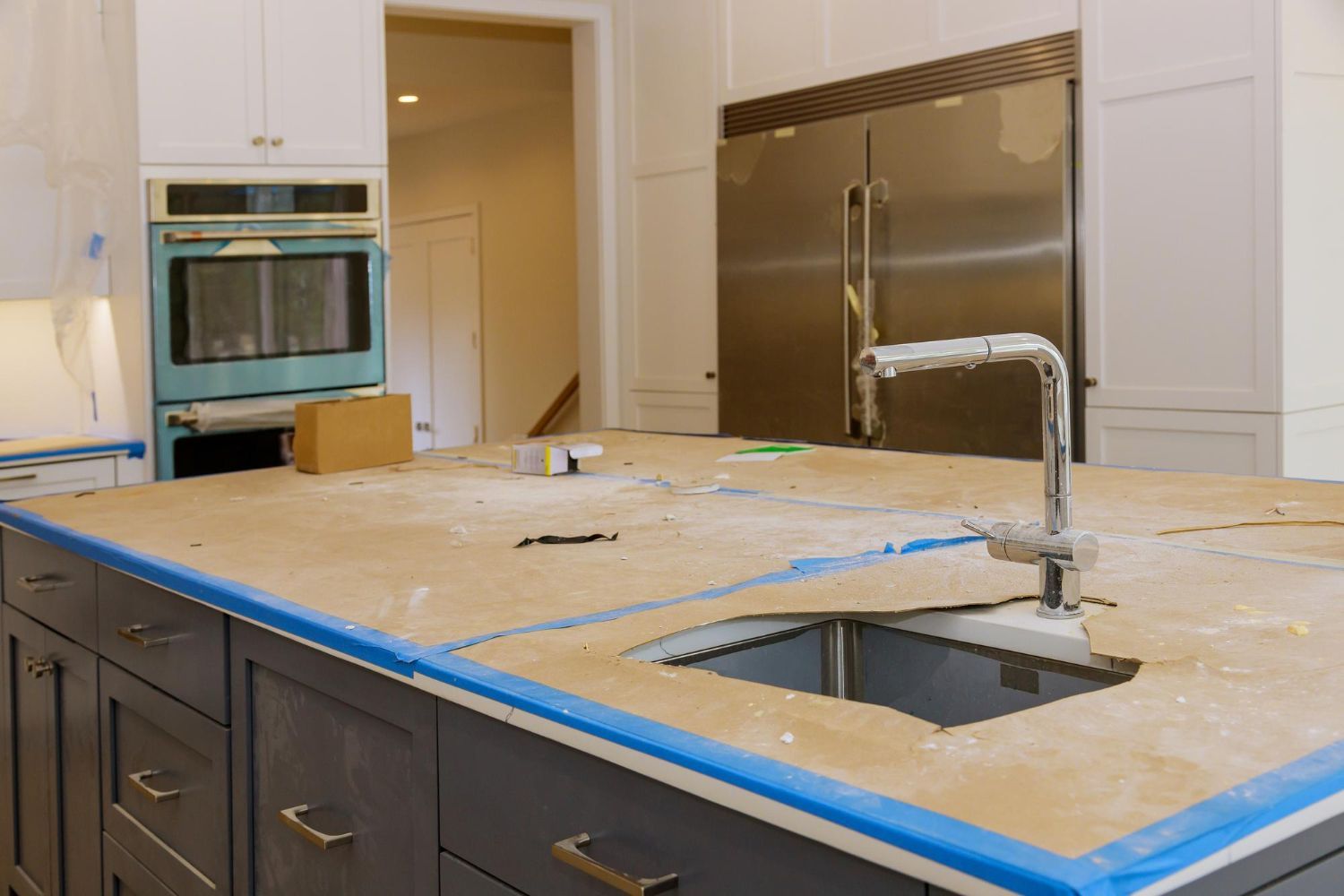 A kitchen with wooden cabinets , granite counter tops , stainless steel appliances and a large island.