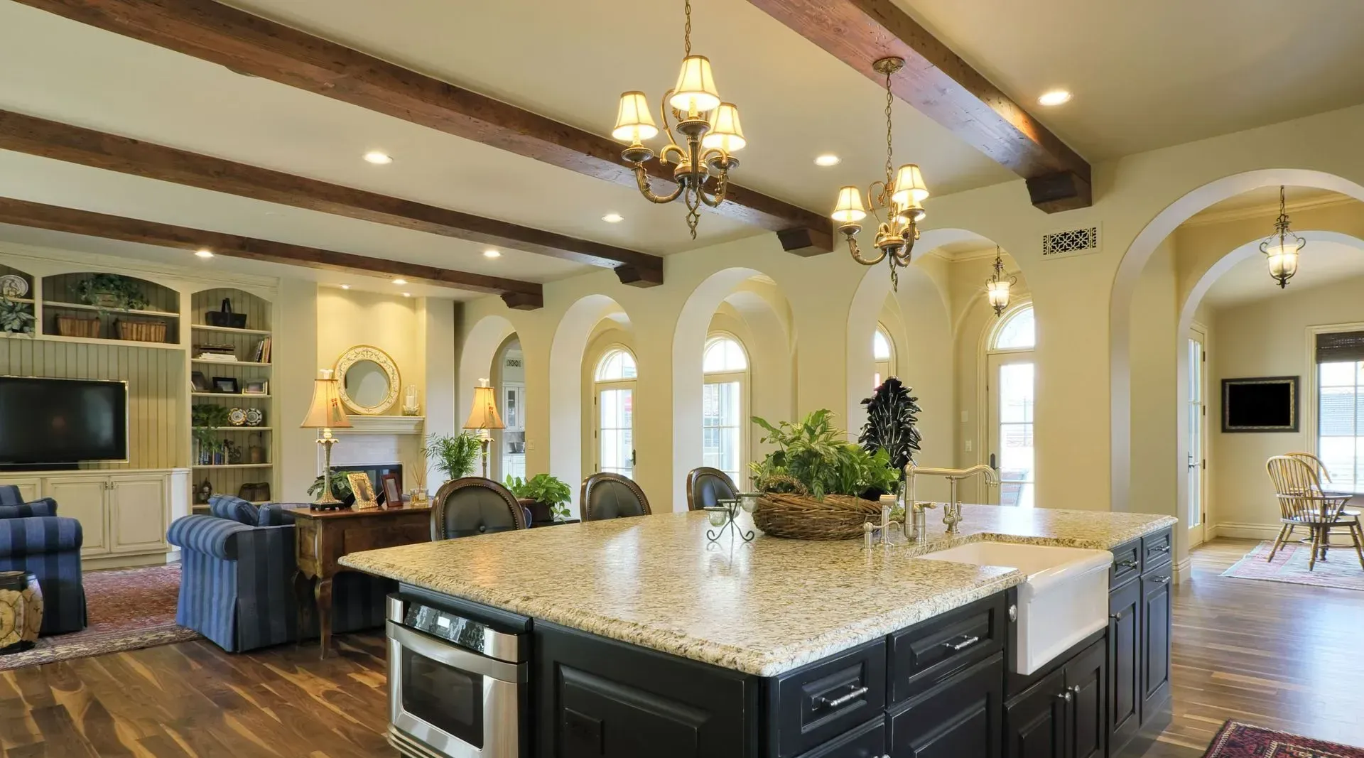 A kitchen with wooden cabinets , granite counter tops , stainless steel appliances and a large island.