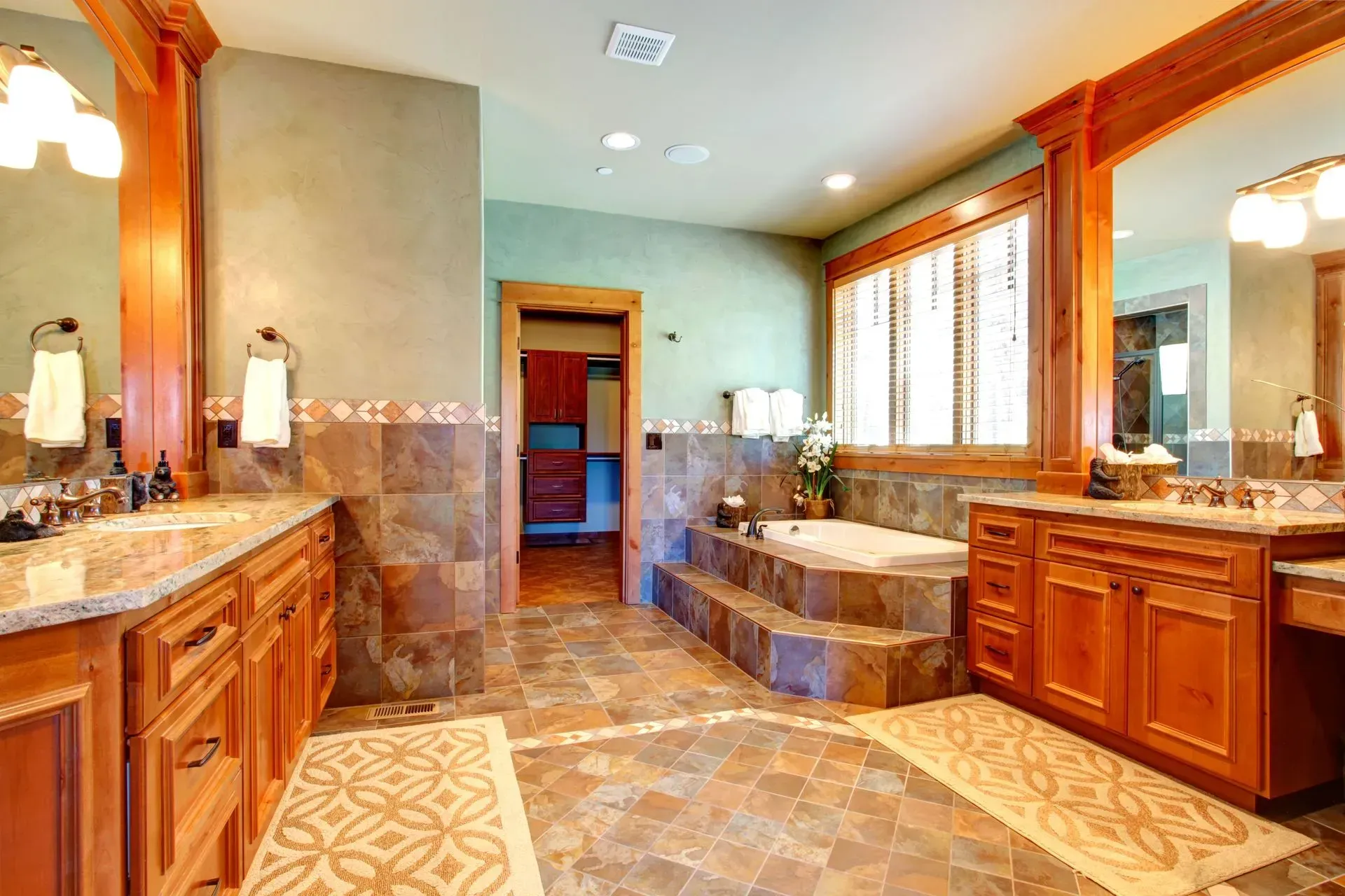 A kitchen with wooden cabinets , granite counter tops , stainless steel appliances and a large island.
