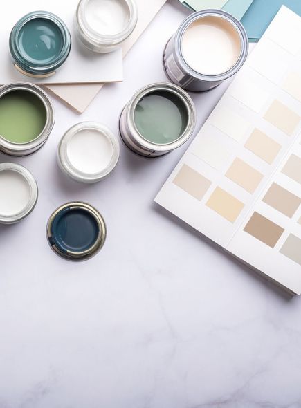 A bunch of paint cans are sitting on a table next to a color palette.