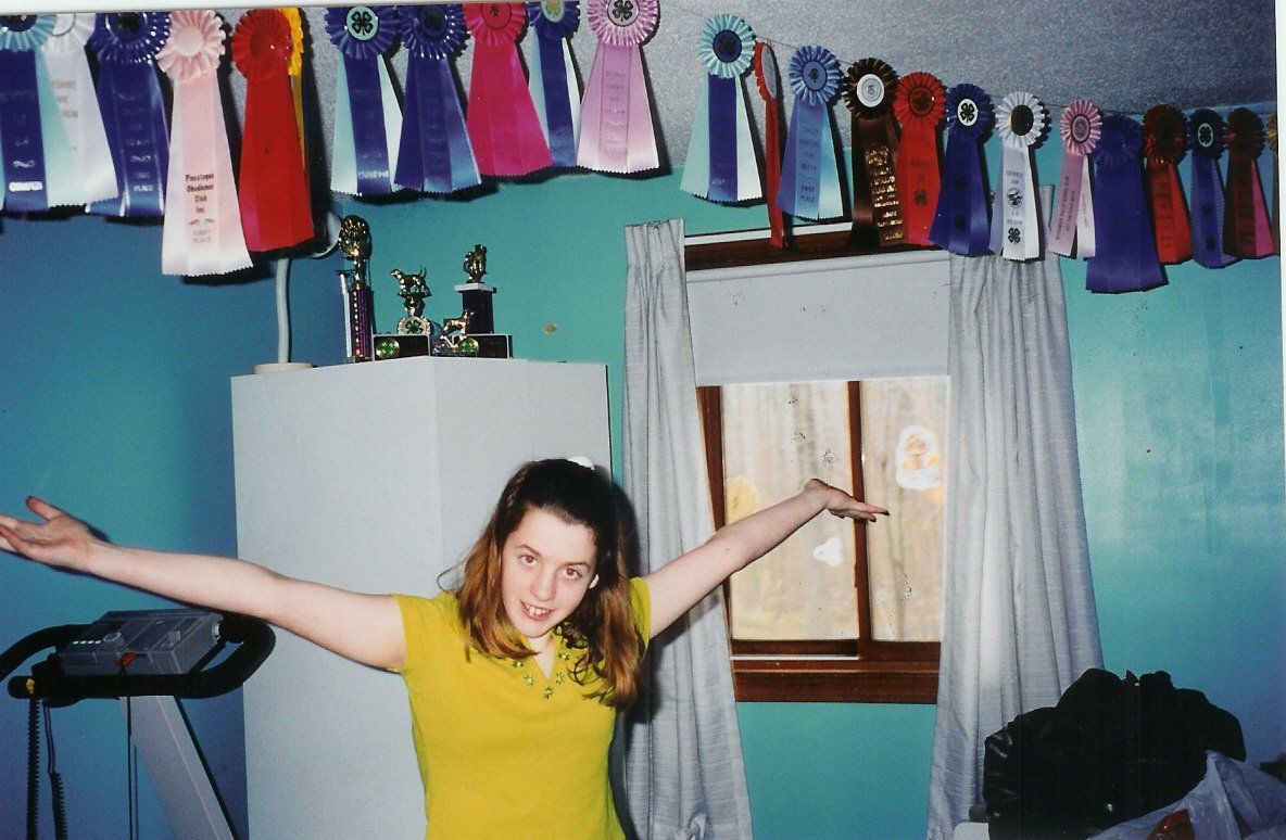 girl showing off dog competition ribbons
