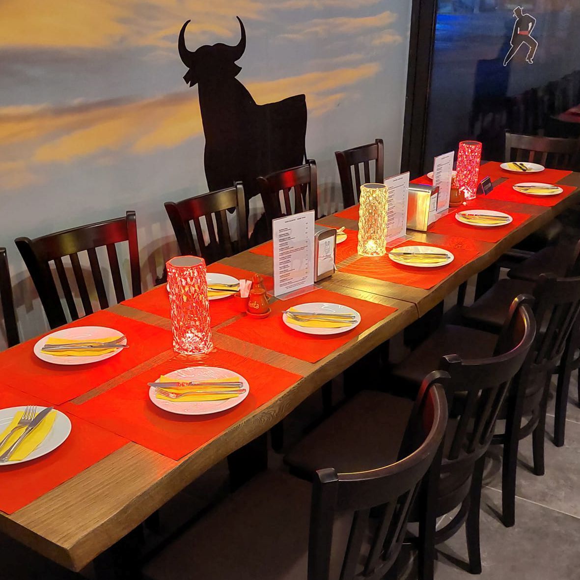 eine gedeckte Tafel mit roten Platzsets im Lokal Hola, Tapas y más