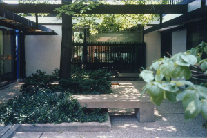 A house with a fence and a bench in front of it