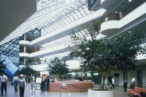 A large building with lots of windows and people walking around