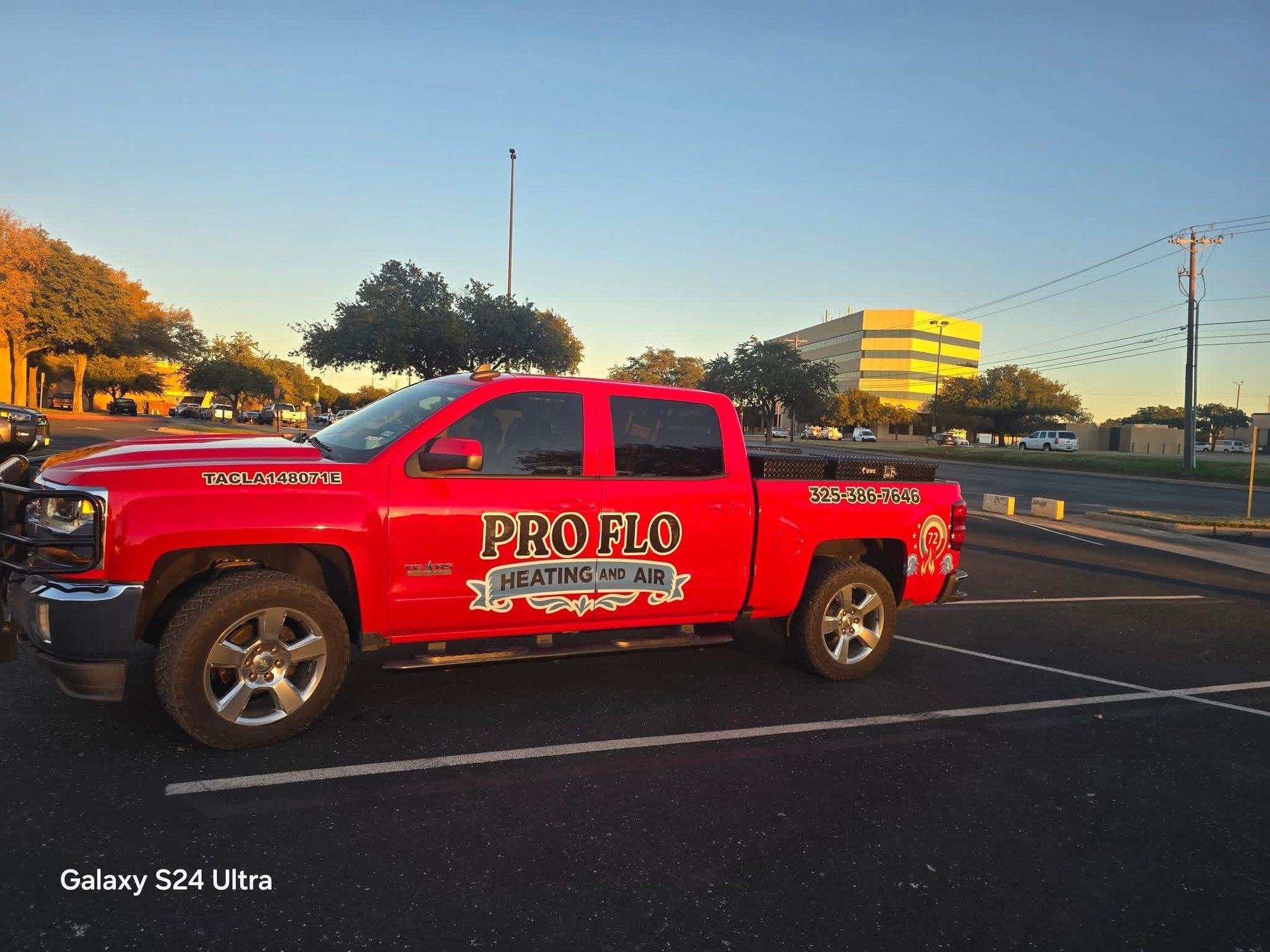 Red ProFlo truck parked in a parking lot at sunset.