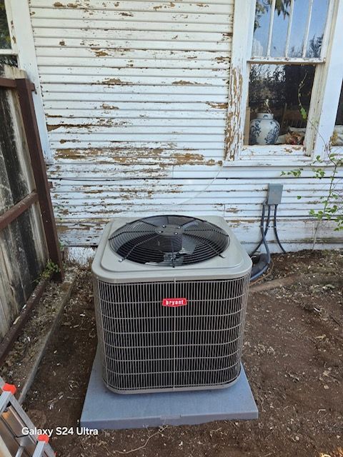 Air conditioner unit outside a building with peeling white paint.