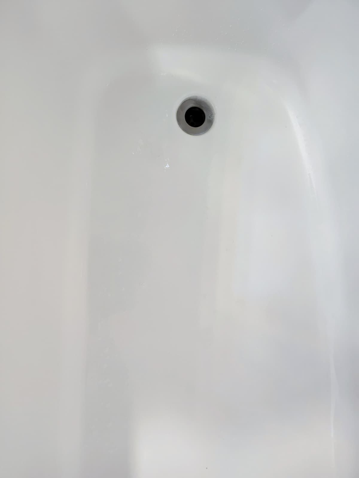 White bathtub interior with a central drain hole
