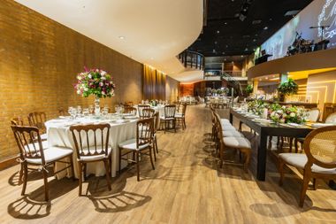 Elegant restaurant interior with white tablecloths, wood chairs, warm lighting, and flower centerpieces