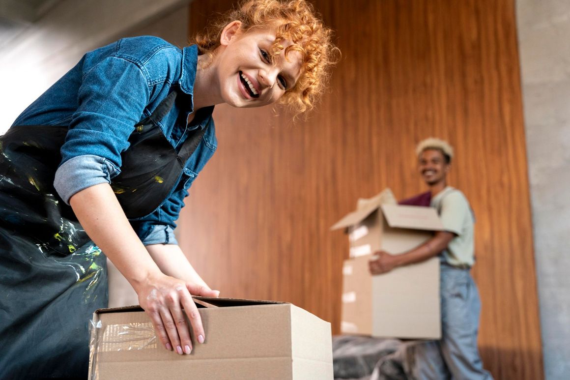 A woman is holding a cardboard box in front of a man holding a cardboard box.
