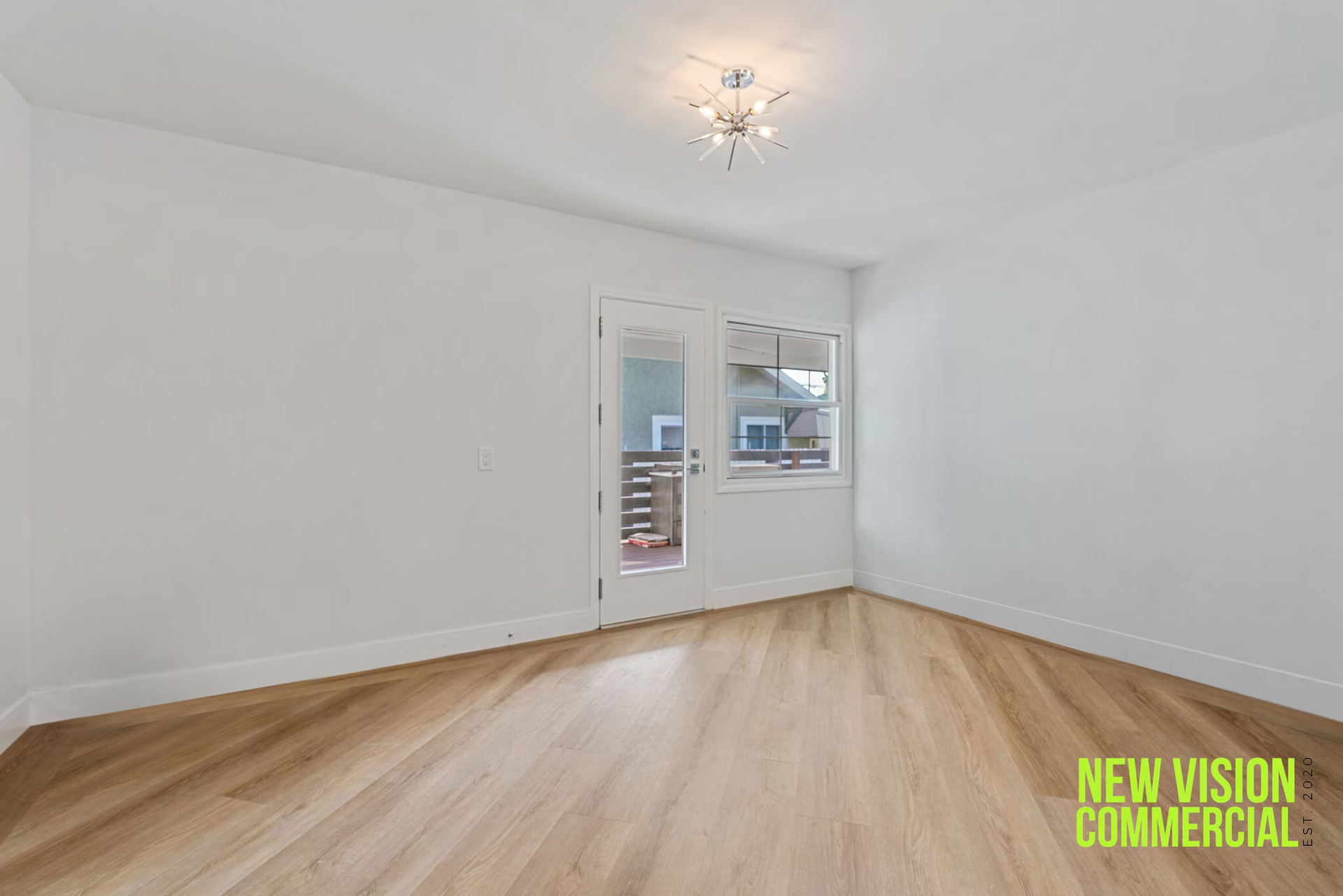 An empty room with hardwood floors and white walls.