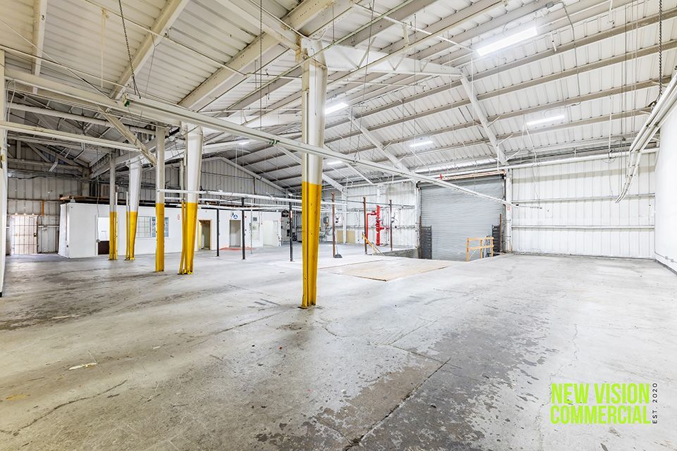An empty warehouse with the words new vision commercial on the bottom