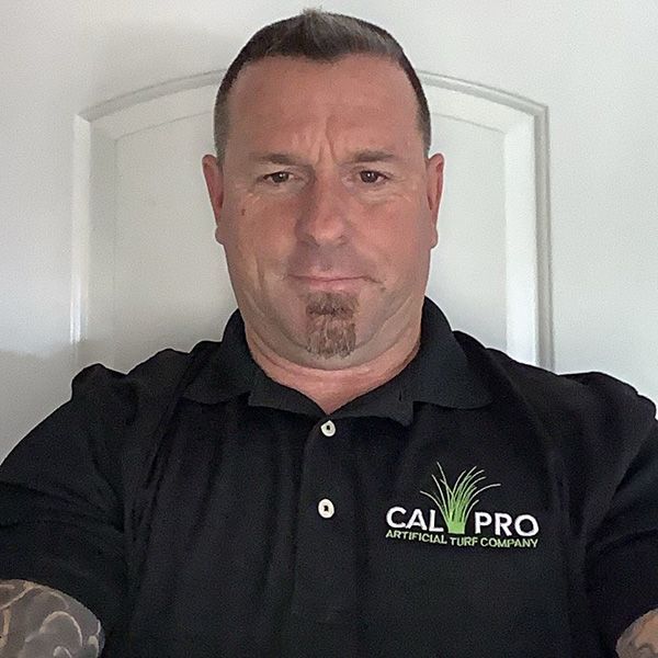 Man wearing a black polo shirt with the logo for Cal Pro Artificial Turf Company.
