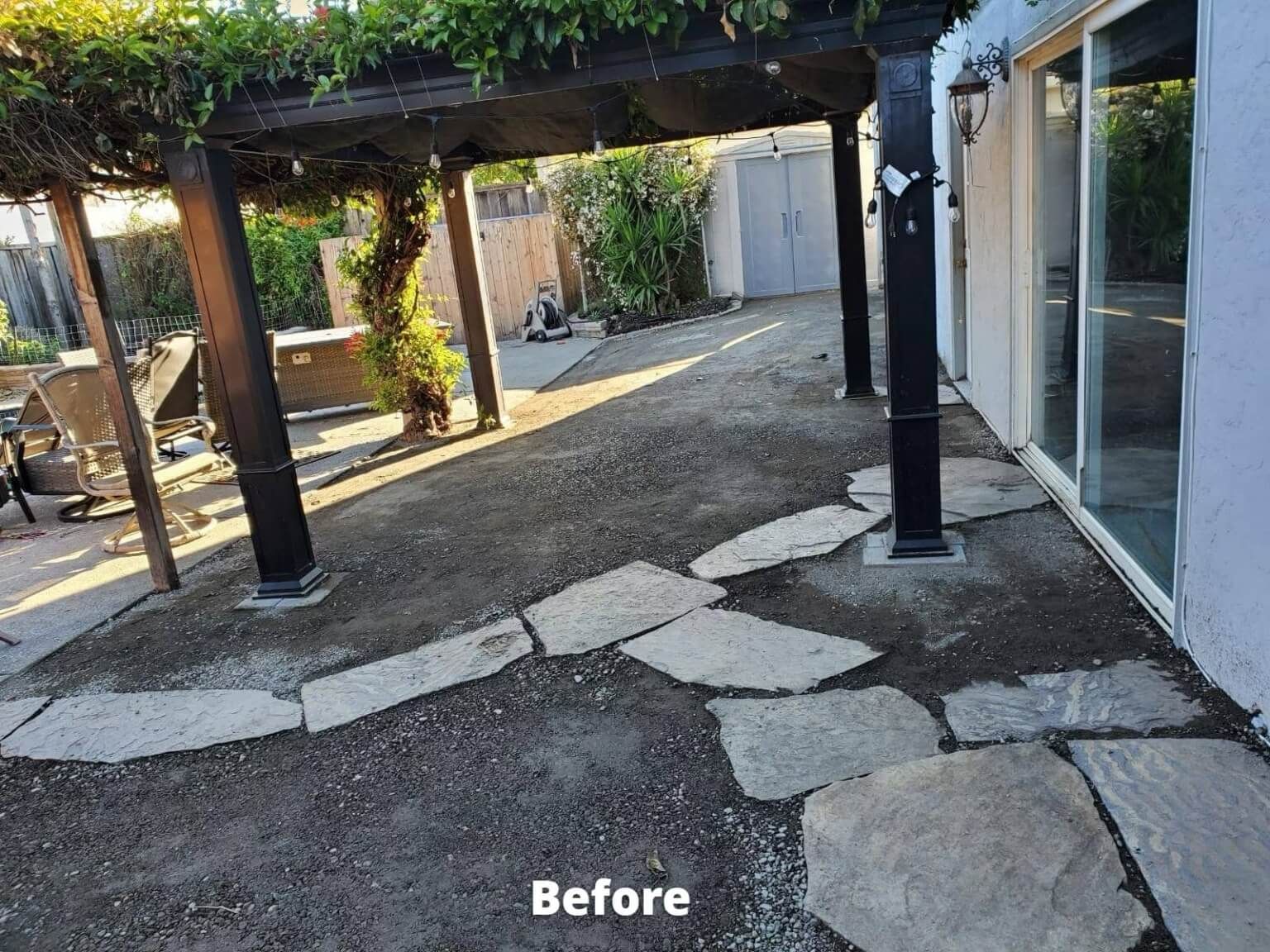 Backyard with pergola, stone pathway, and gravel. Before renovation.
