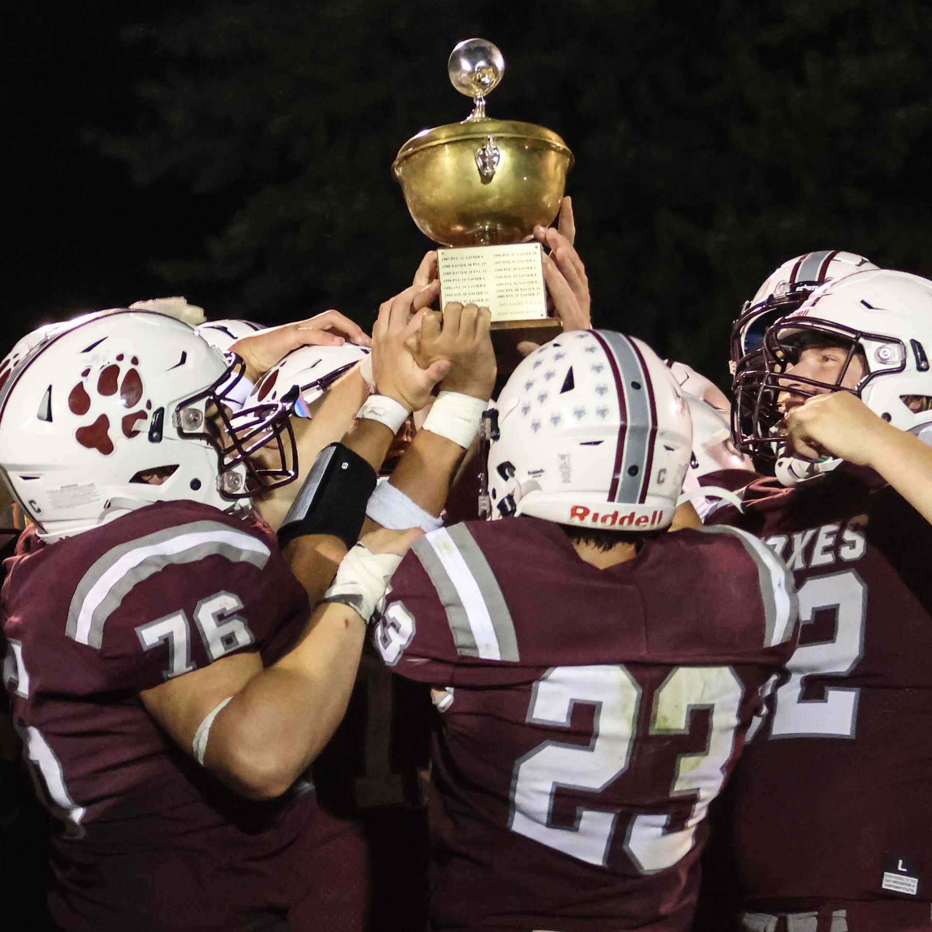 Some football team members holding the Apple Bowl trophy