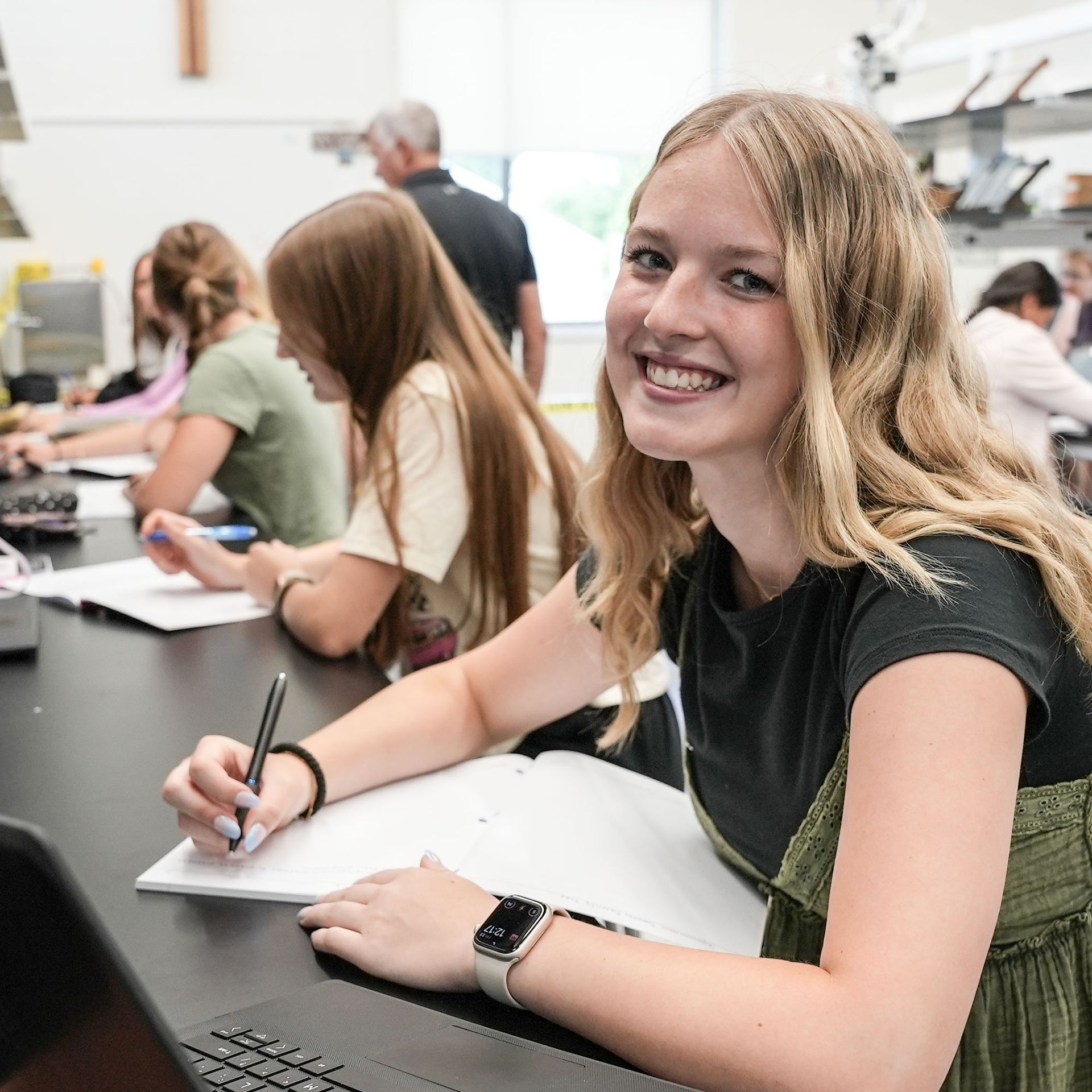 Smiling female student sitting in a science lab