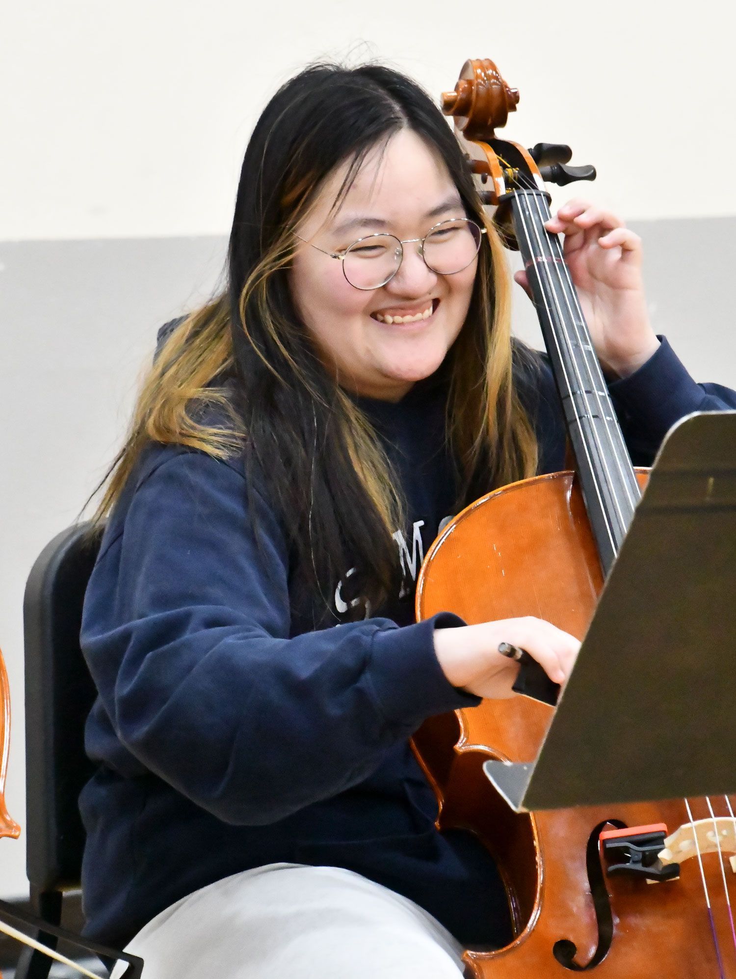 Happy female student playing a stringed instrument