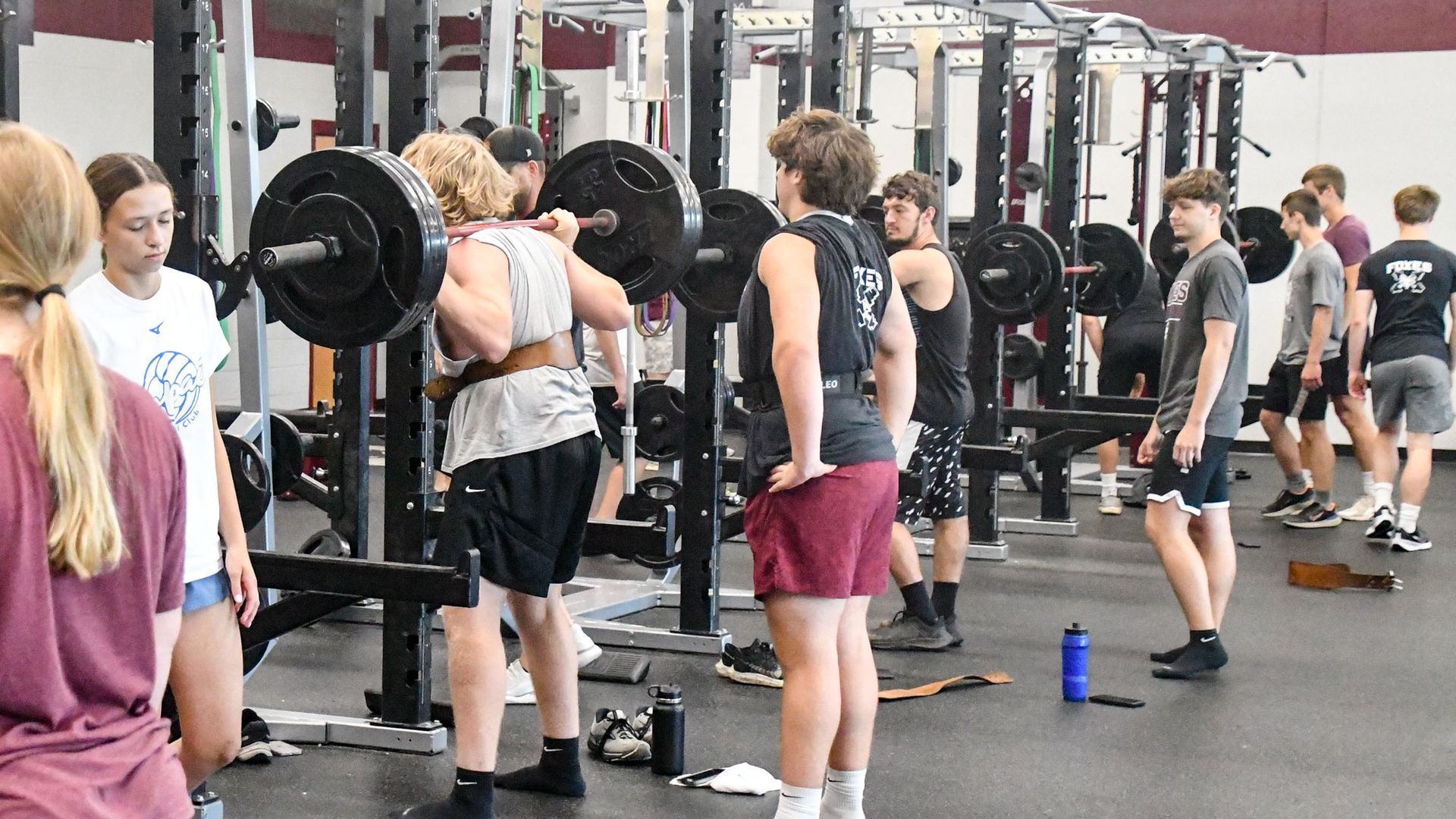 Lots of students using and waiting for lifting equipment in the fitness center