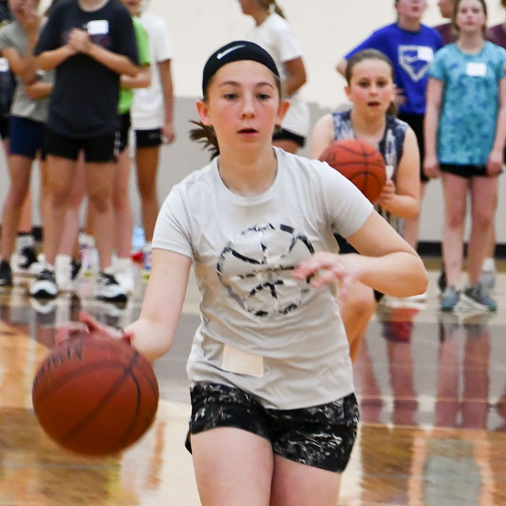 Female student, dribbling a basketball in the gym
