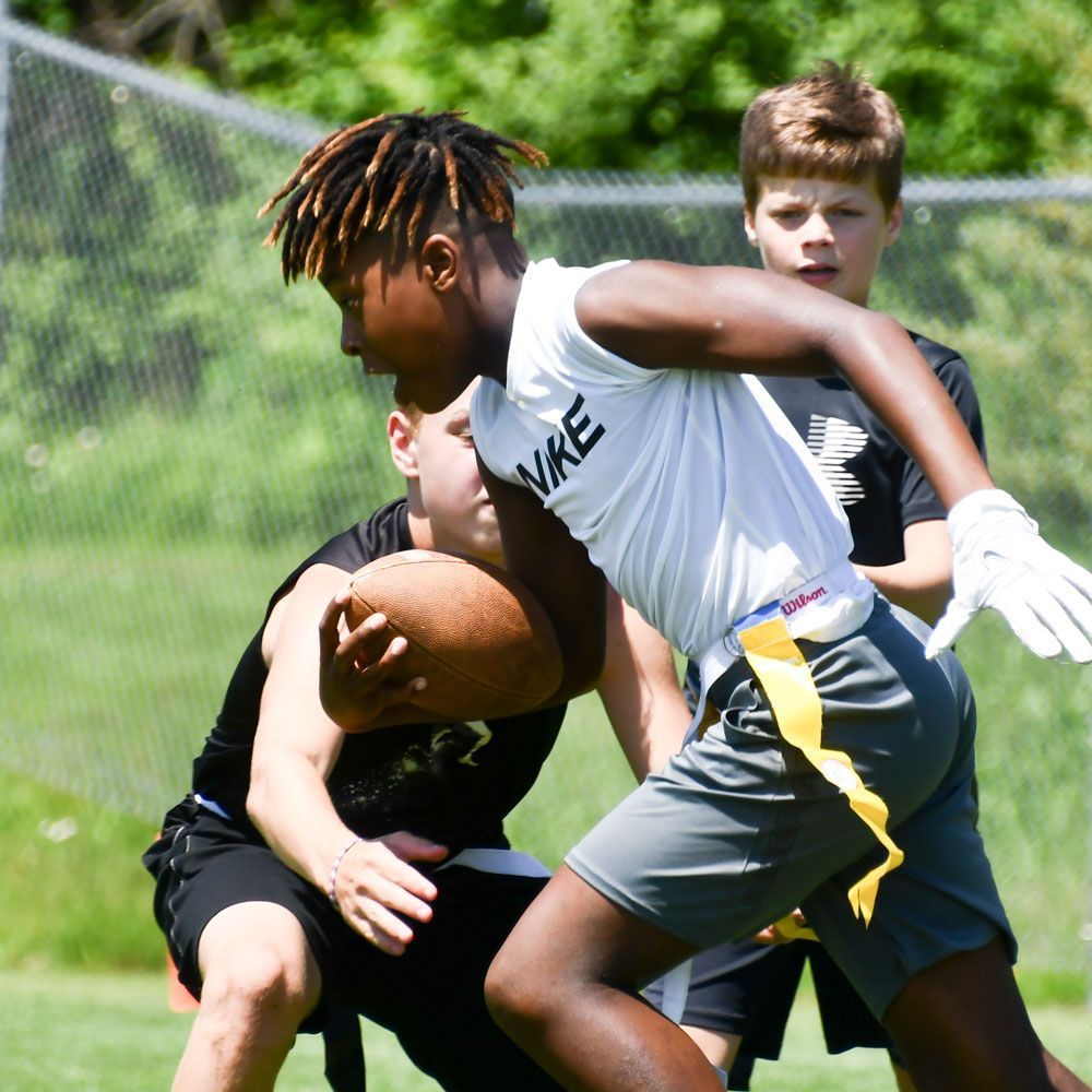 Young male student running with the football