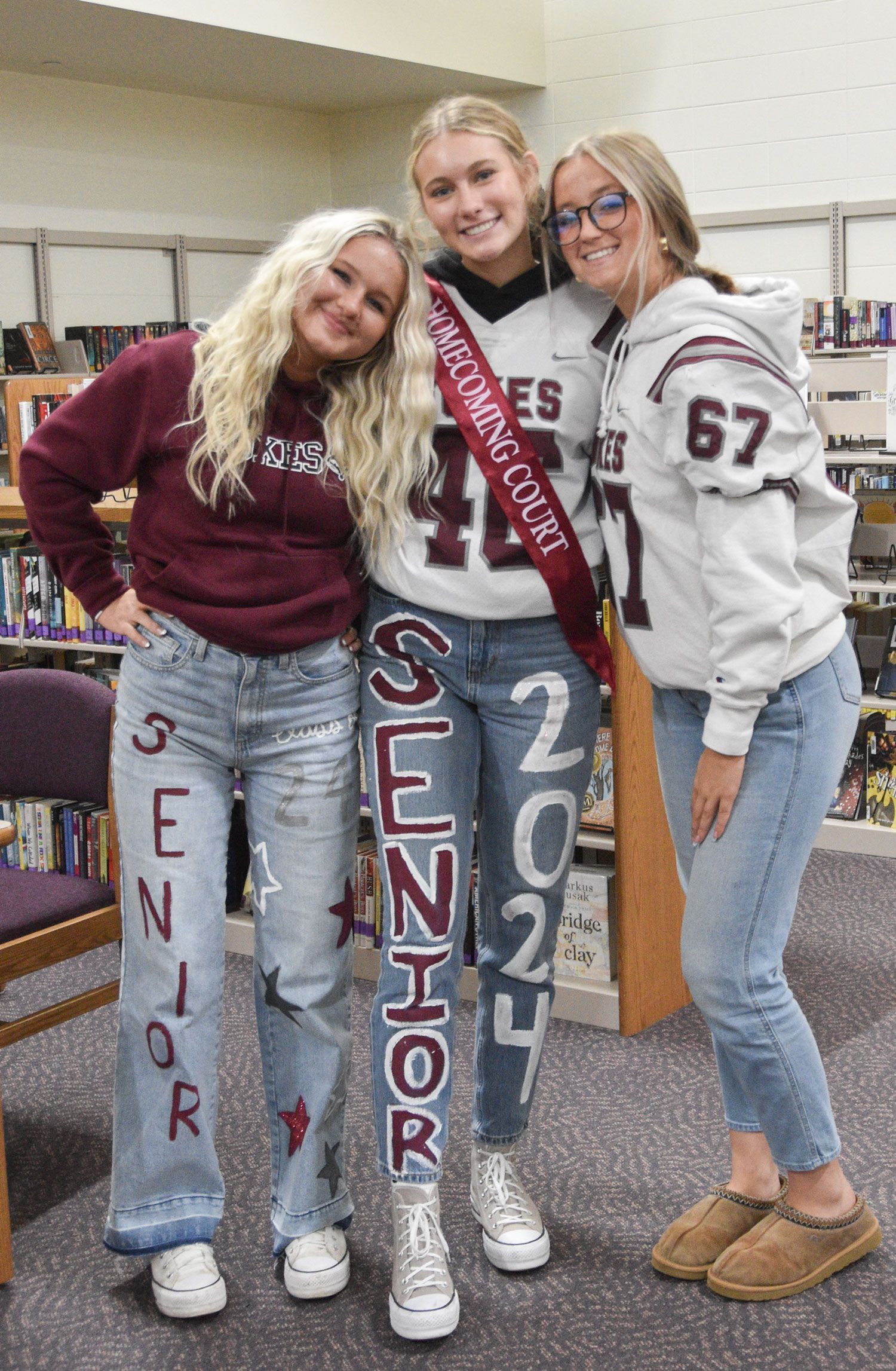 Three smiling girls in the Media Center in their FVL Spirit Day clothes