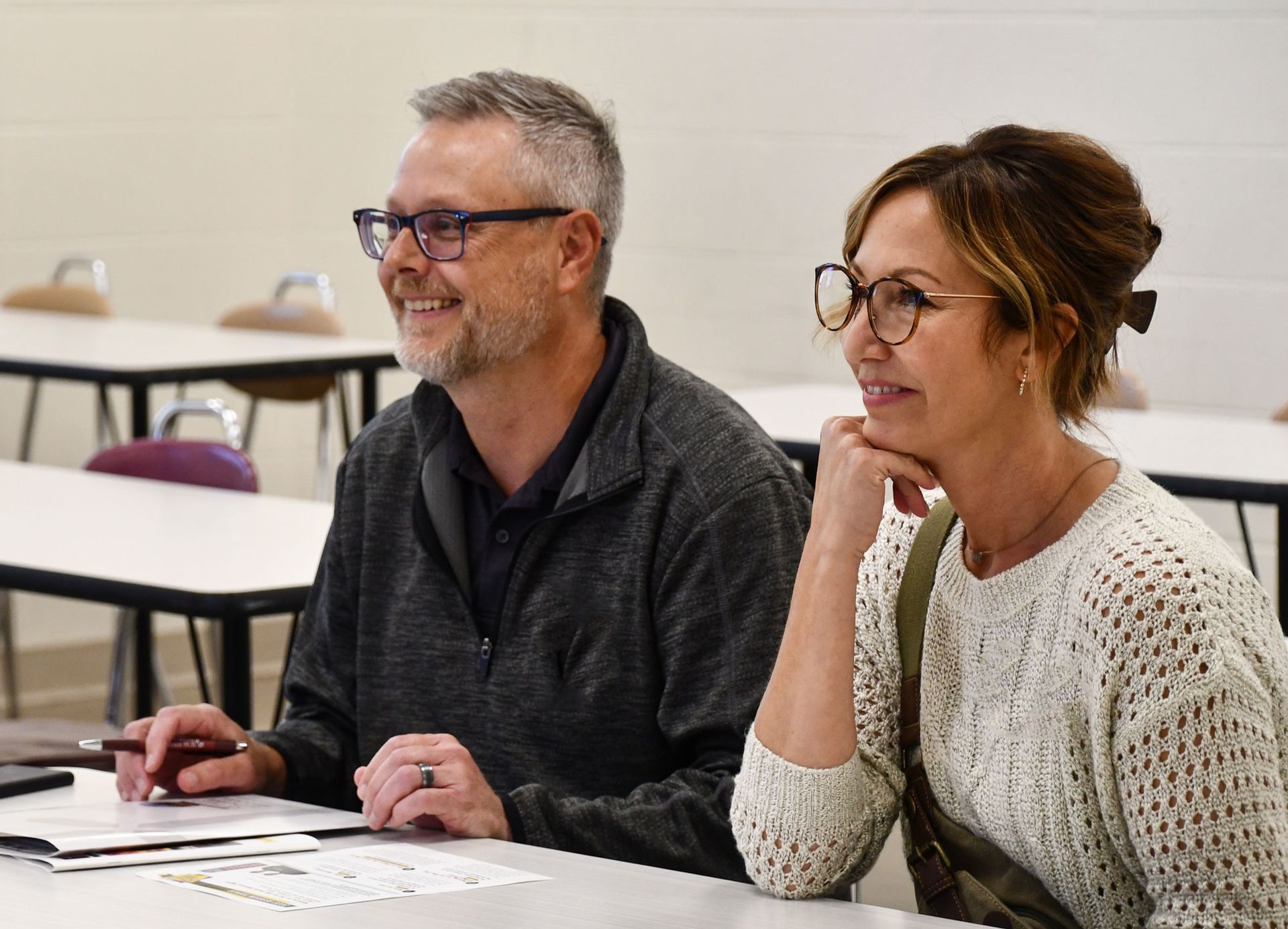 Smiling parents at a table during one of the parent session