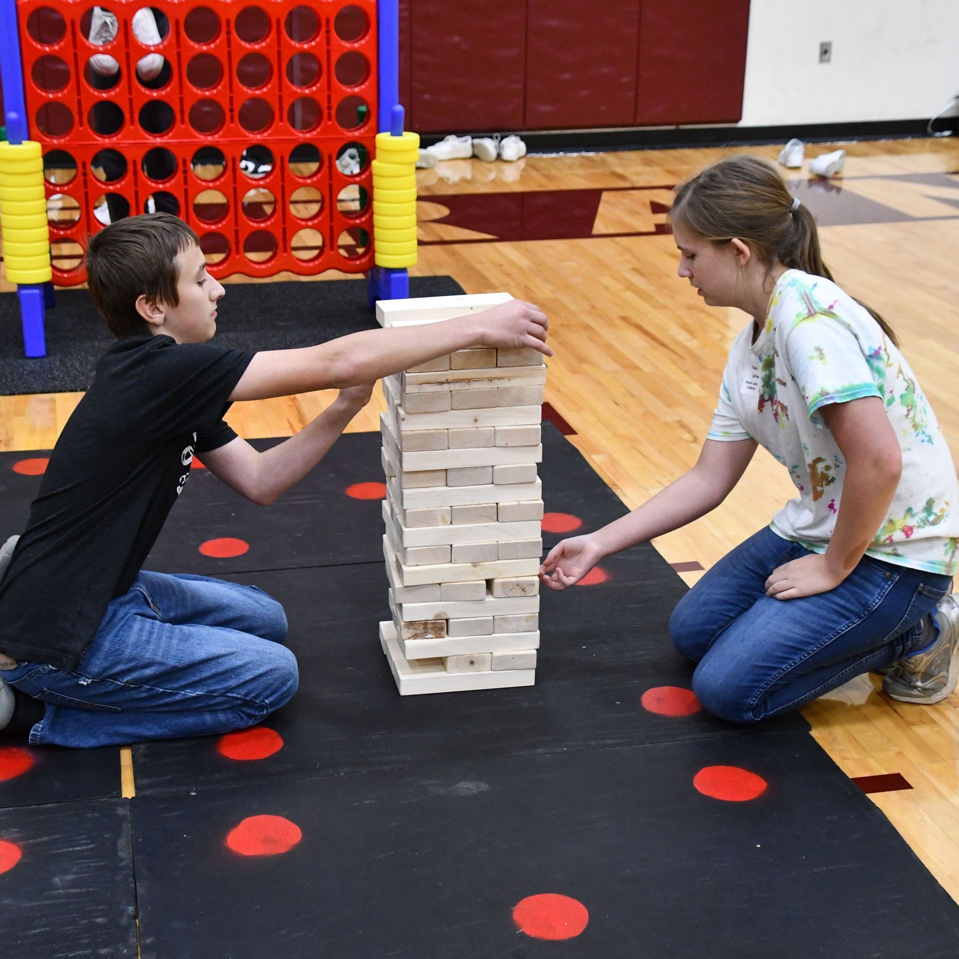 Students playing giant Jenga with giant Connect 4 behind them
