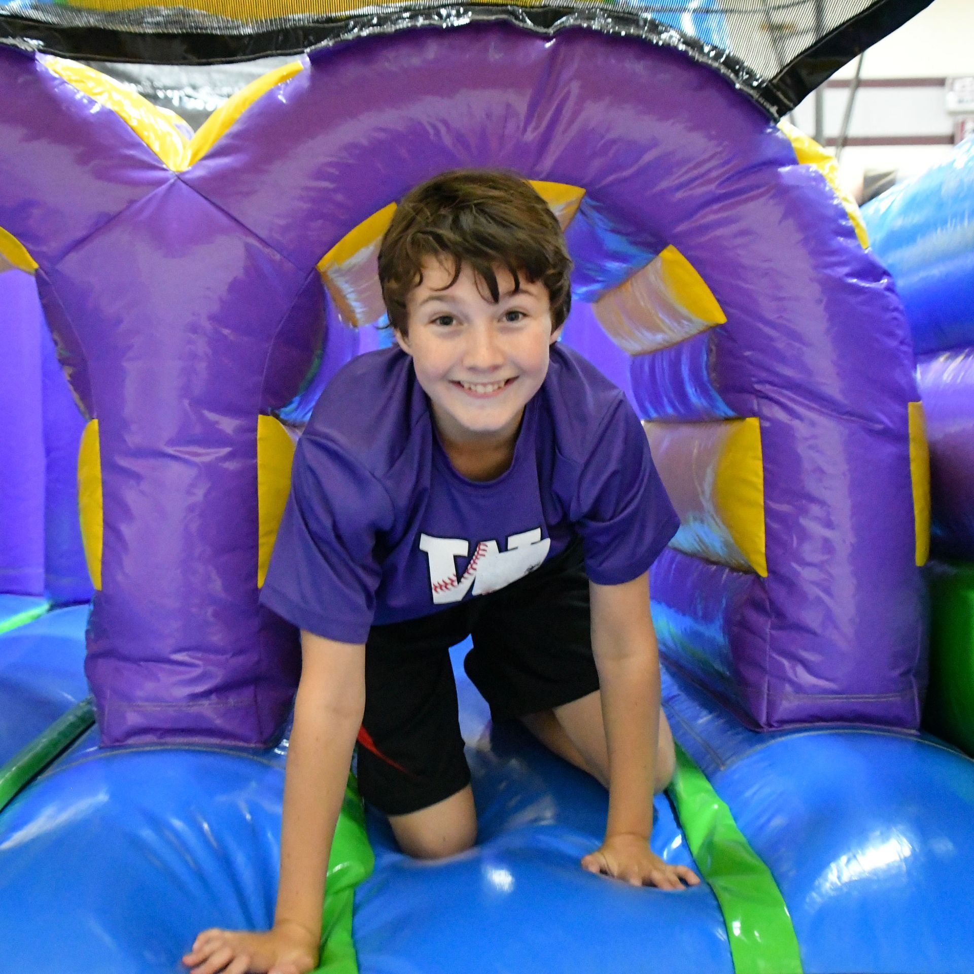 Smiling boy looking at the camera while playing on colorful inflatable