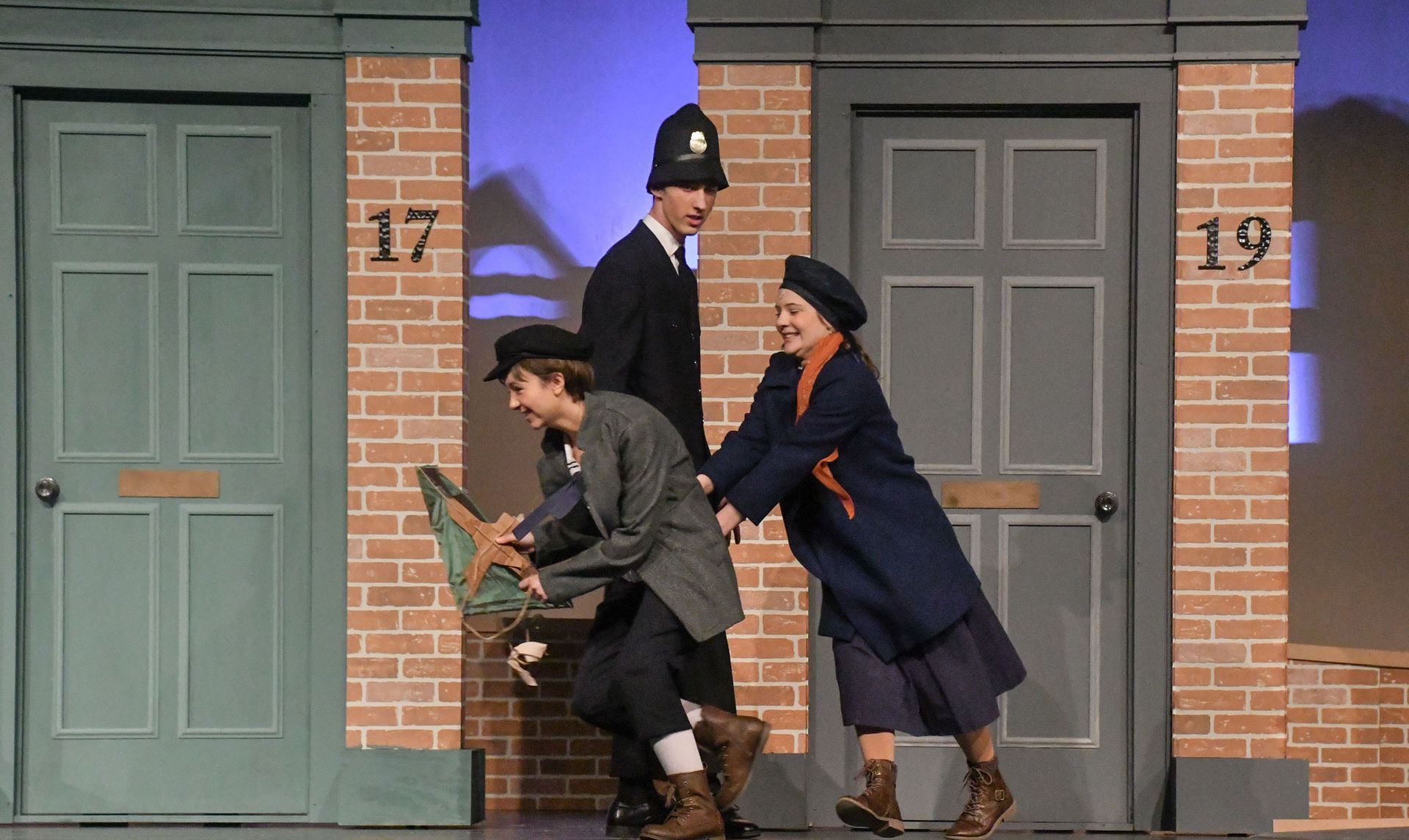 Jane and Michael outside their house as a police officer watches them
