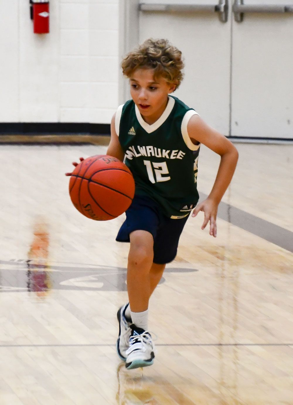 Young male student dribbling a basketball during last year's camp