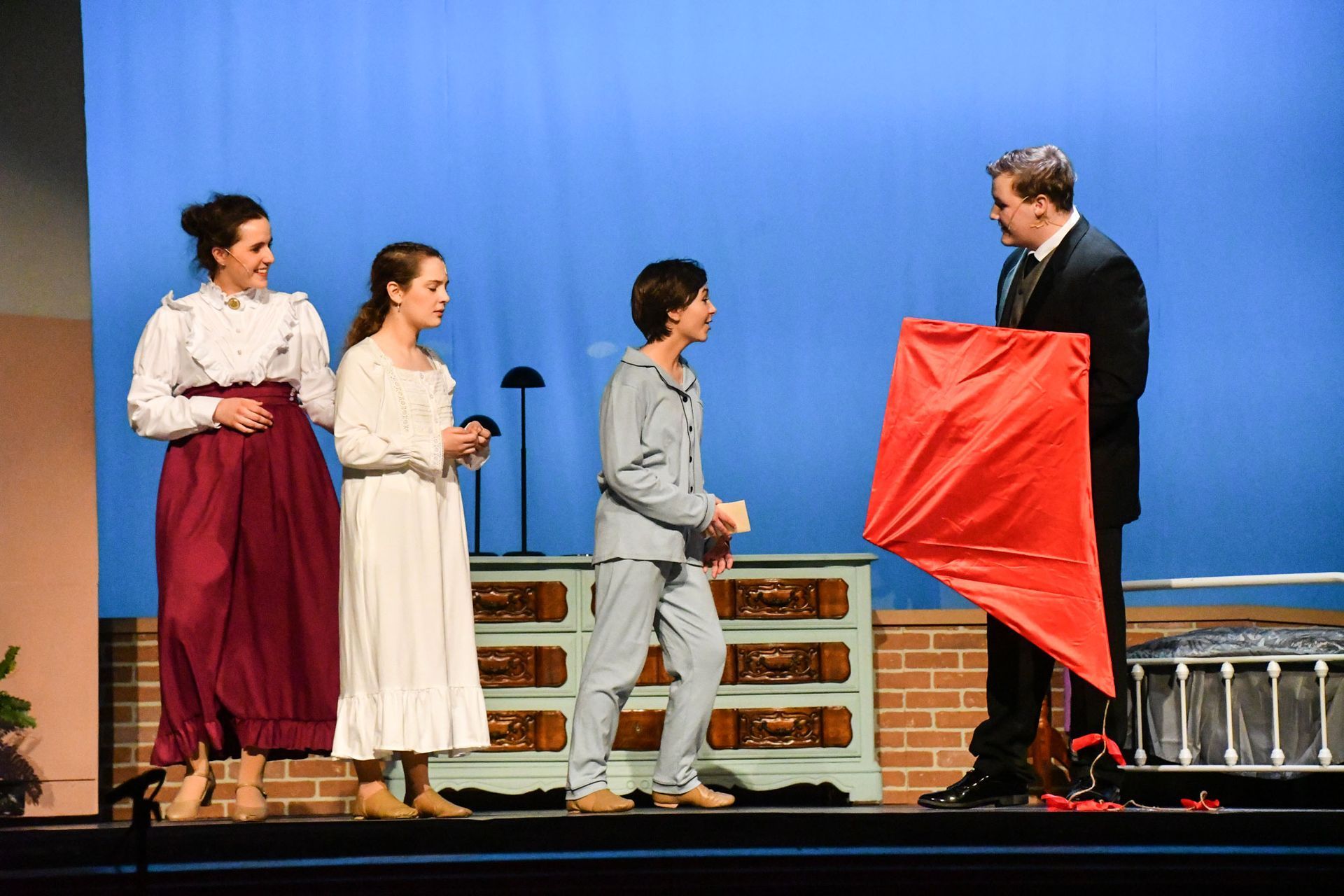 Mr. Banks with a kite, talking to Mrs. Banks, Jane, and Michael.