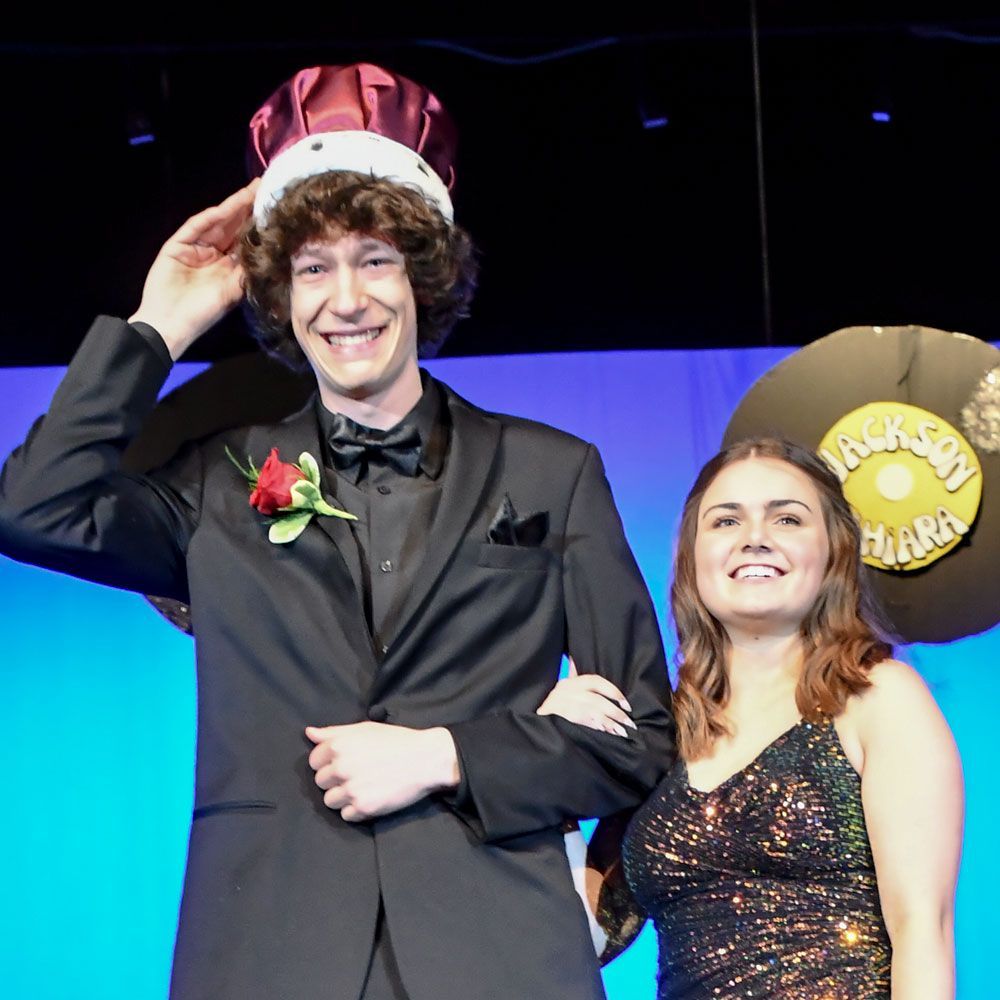 Newly crowned Prom King Nick Kraftzenk, with his escort, Miranda, standing next to him on stage