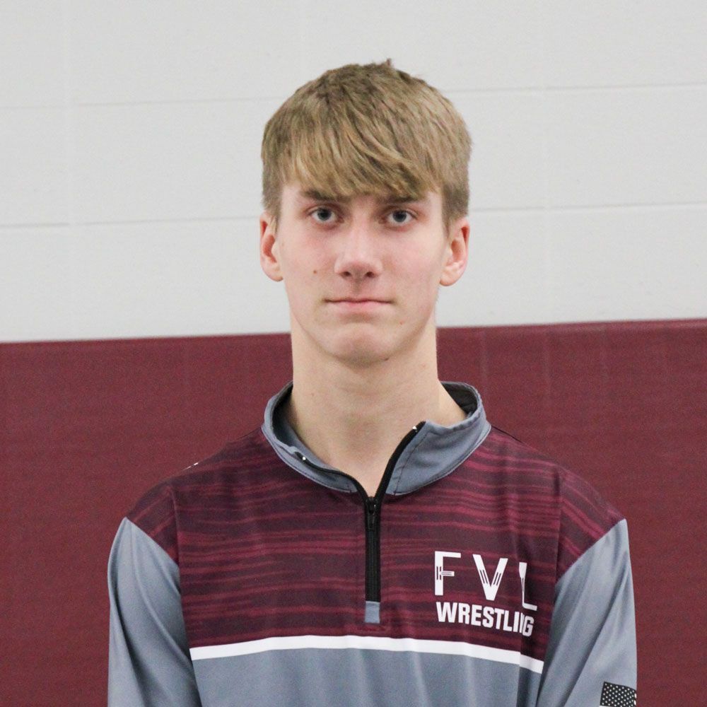 Head shot of Austin in the gym, and in his wrestling uniform jacket