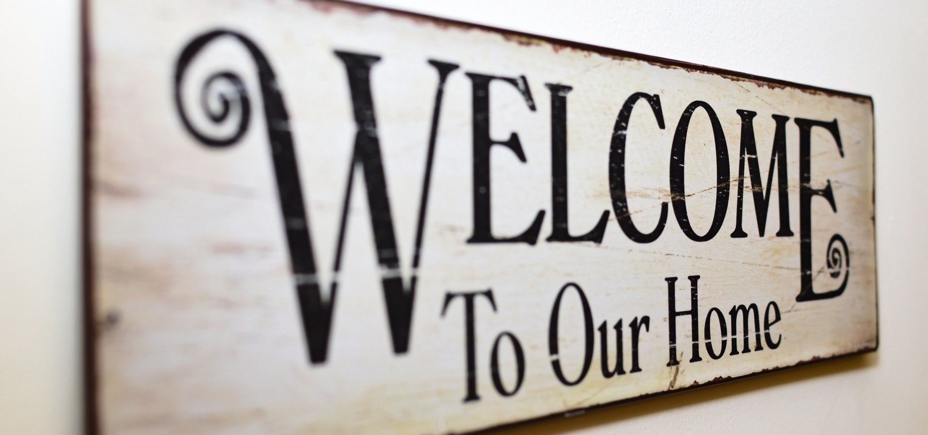 Sign with a wooden look that says Welcome to our Home