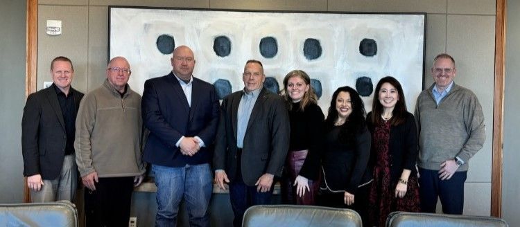 A group of people are posing for a picture in a conference room.