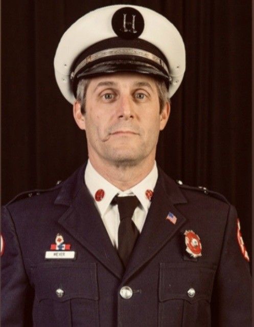 A man in a uniform has the letter u on his hat